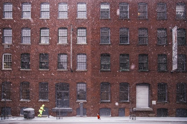 winter scene with snow in front of brick building